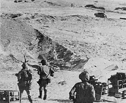 Photographie montrant des soldats égyptiens dans le désert du Sinaï tirant des chariots de bois.