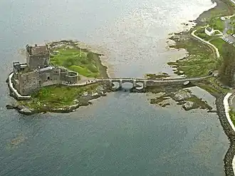 Vue aérienne d'Eilean Donan, de son château et de son pont baignés par les eaux du loch Duich.