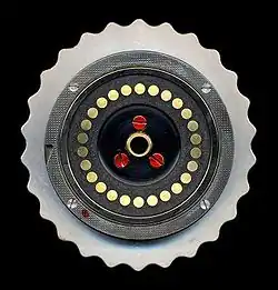 Autre face du rotor, montrant les contacts plats. L'encoche entraînant le mouvement du rotor est visible à la gauche du disque.