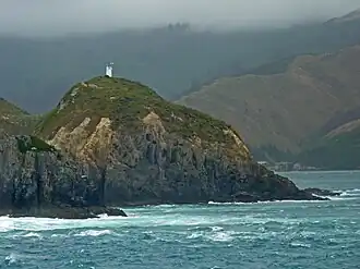 Photographie couleur d'un cap battu par la mer.