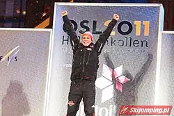 Un homme lève les bras sur un podium