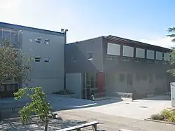 Photographie de deux bâtiments de deux et trois niveaux, à toit plat.