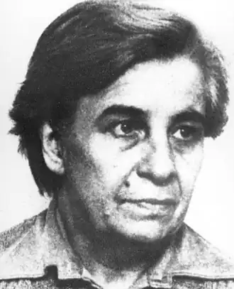 portrait noir et blanc de 3/4 d'une femme d'une cinquantaine d'année. Un grain de beauté sur la joue droite.