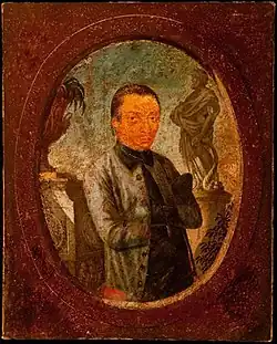 Peinture en couleurs. À l'intérieur d'un médaillon marron, Aleijadinho, peint dans un style naïf, porte une veste grise et cache ses mains entre les boutons frontaux de sa chemise d'un vert foncé.