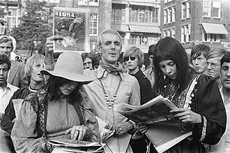 photo en noir et blanc d'un groupe de personnes lisant un magazine
