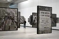 Photographie noir et blanc d'une série de photos exposées en grand format, suspendues dans une salle