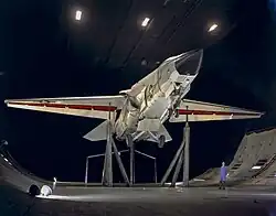 A F-111B on support inside a large wind tunnel