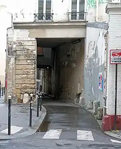 Cette voie, côté rue Amelot, passe en partie sous un immeuble.