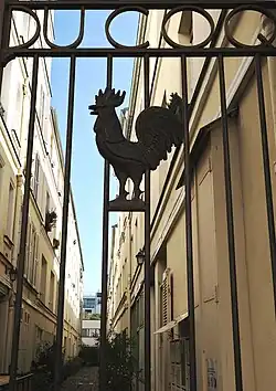 Le portail d'entrée avec une silhouette de coq.