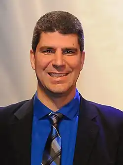 Photographie d'un homme en costume et chemise bleus