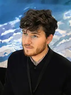 un homme cheveux bouclés avec une barbe.