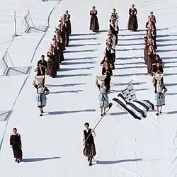 Vue d'un défilé sur 3 rangs d'un groupe folklorique breton.