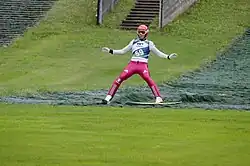 Un sauteur à ski lors de la réception de son saut.