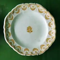 Assiette octogonale en camaïeu jaune, guirlande fleurie et bouquet central.