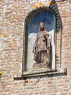 Face à l'église, sainte Cécile et sa lyre.