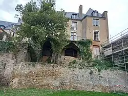 Vestiges d'une muraille et d'un échafaudage, et deux embrasures ouvertes en ogive, surmontés d'un bâtiment