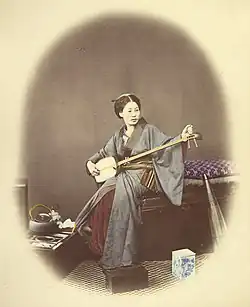 Photographie des années 1860 d'une joueuse de shamisen.