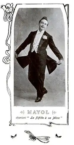 Photographie en médaillon d'un chanteur en costume, prenant une pose, l'image étant sous-titrée et entourée d'une bordure à motif végétal.