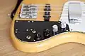Prise jack (en bas à gauche) et potentiomètres sur une Fender Jazz Bass signature Marcus Miller. Un capot est également présent sur le micro manche, pour pouvoir y poser la main droite.