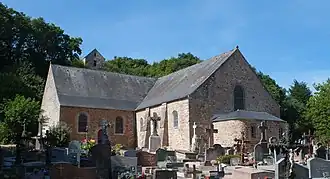 Une petite église romane au pied d'une colline.