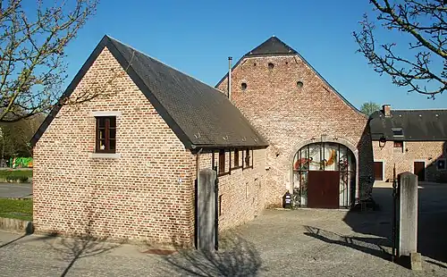 L'entrée de la ferme et la grange transformée en salle de spectacle.