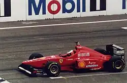 Photo vue de gauche d'une monoplace rouge en piste