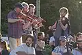 Violonistes traditionnels sur un plateau de danse.