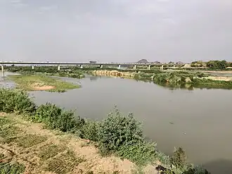 Lit du cours d'eau Bénoué en période sèche. Le pont en arrière-plan.