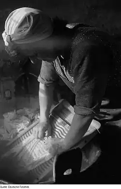 Femme allemande utilisant vers 1947 une planche à laver pour la lessive manuelle, ce qui est la fonction originelle de cet objet.