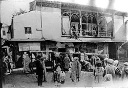 Photo en noir et blanc d'un vieux bâtiment de style mauresque sur une place de arché