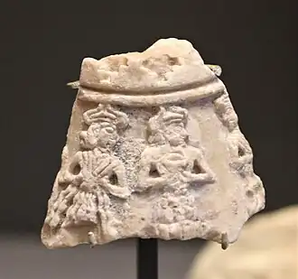 Fragment de masse d'armes représentant avec dieu montagne et déesse au vase jaillissant, mis au jour dans le secteur des temples.
