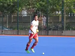 Un homme vu de face tenant une cross de hockey.