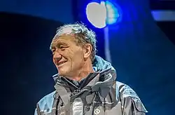 De nuit, portrait, souriant, veste de quart grise.