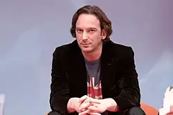 Photographie en couleurs d'un homme assis vu de face