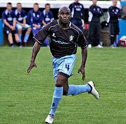 un joueur de football en mouvement cherchant le ballon des yeux