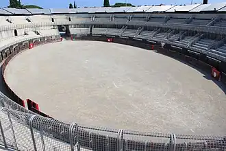 Grilles galvanisées, gradins de béton, tôles ondulées.