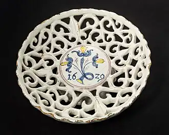 Coupe à pied (environ 7 cm de haut, 20 cm de diamètre), en faïence ajourée à glaçure au dioxyde d'étain en forme de vigne, produite en 1629 dans l'ouest de la Slovaquie/Moravie (peut-être à Sobotište), l'une des plus anciennes œuvres connues des Haban&nbsp;(de).