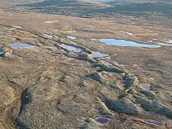 Longue butte de sédiments sur un terrain plat.