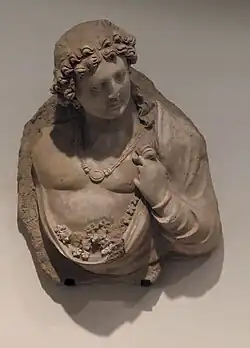 Génie aux fleurs. Monastère de Tapa-Kalan. Hadda IIIe - IVe siècle Stuc. H. 55cm. Musée Guimet.