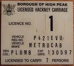 Plaque de licence de taxi au Royaume-Uni dans les années 1990.