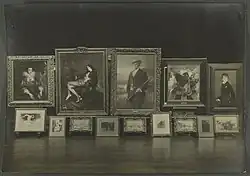 Deux rangées de tableaux, de formats différents, conservés dans la galerie Henry Vasnier, sont posés sur des chevalets.