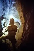 Homme debout dans une cavité souterraine.