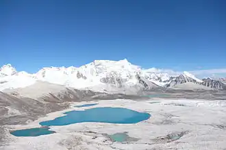 Vue du versant ouest du Gangkhar Puensum depuis le Gophu La, avec à gauche du sommet la longue arête horizontale qui mène à son sommet secondaire, le Liankang Kangri (7&nbsp;535&nbsp;m).