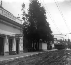 Photographie en noir et blanc d'une grande gare avec voies électrifiées, à gauche du cliché apparaît une station du funiculaire de Grasse.