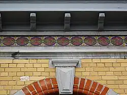 Frise en céramique et arc en plein cintre.