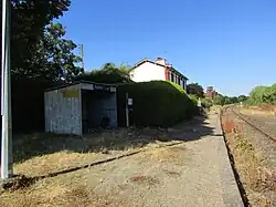 Vue de la gare de Plaintel avec l'abri de quai, et l'ancien bâtiment voyageur en arrière plan.