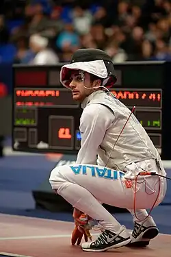 Un escrimeur accroupi sur la piste de compétition.