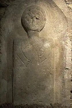 Stèle celtique figurant un personnage portant une chandelle.