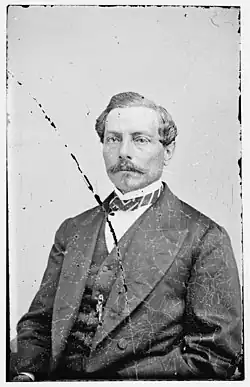 Portrait en noir et blanc d¿un homme âgé en costume gris.