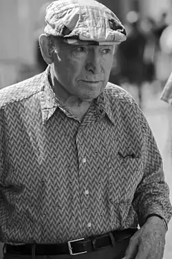 photo noir et blanc d'un vieil homme en chemise, avec une casquette à carreaux